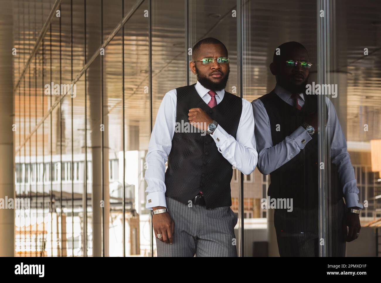 Ritratto di un uomo d'affari afro americano in tuta sullo sfondo di un edificio moderno esterno Foto Stock