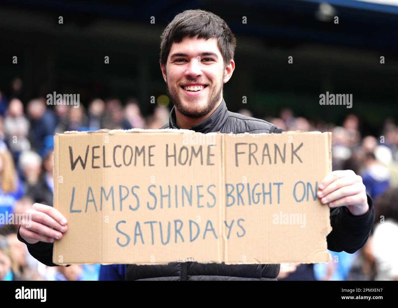 Un ventilatore tiene in mano un cartello che dice "Welcome Home Frank. Le  lampade brillano il sabato a metà tempo durante la partita della Premier  League a Stamford Bridge, Londra. Data immagine: