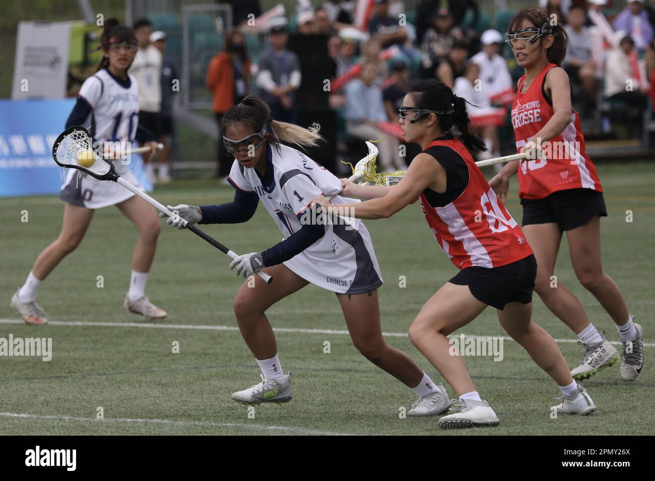 Finale femminile: Hong Kong WRT (camicia rossa) batte il cinese Tai Pei di 14-6 all'Hong Kong Lacrosse Open di Tseung Kwan O. l'immagine mostra Yang Jie-yu di Taipei (#1) in azione. 10APR23 SCMP/Xiaomei Chen Foto Stock