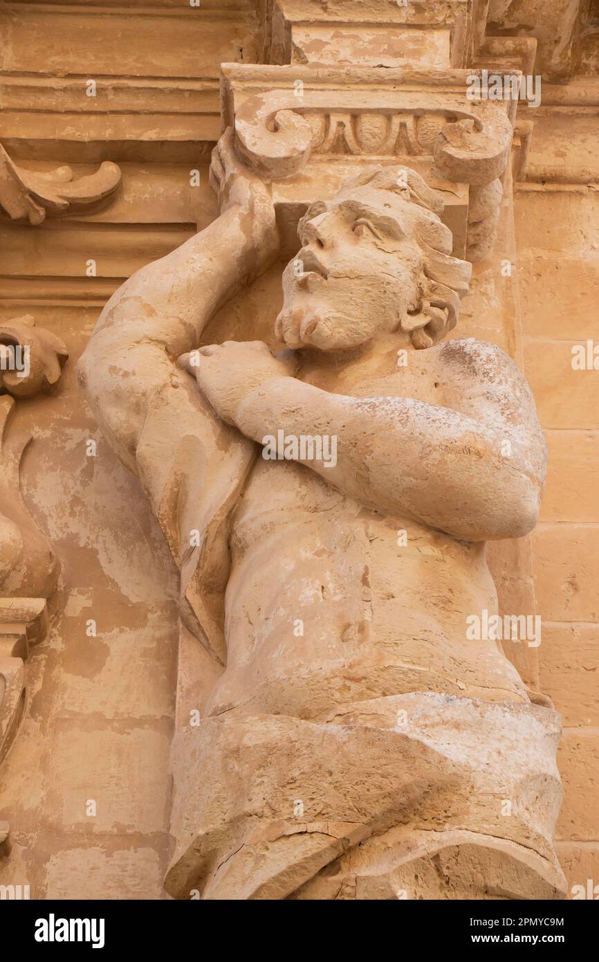 Mdina, Malta - 13 novembre 2022: Particolare della facciata del Museo della Cattedrale di San Paolo, un atlantico, figure maschili come lesene, statua di pietra calcarea che regge Foto Stock