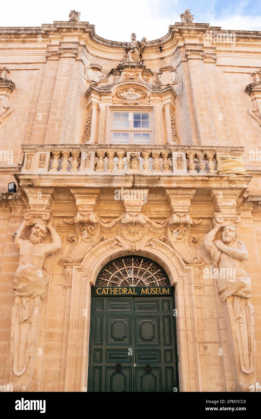 Mdina, Malta - 13 novembre 2022: Facciata d'ingresso del Museo della Cattedrale di San Paolo con due atlanti, figure maschili come lesene e un balcone sopra di essi Foto Stock