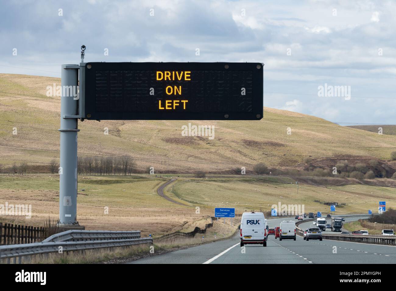 Prosegui sul cartello a sinistra sull'autostrada M74, Scozia, Regno Unito Foto Stock