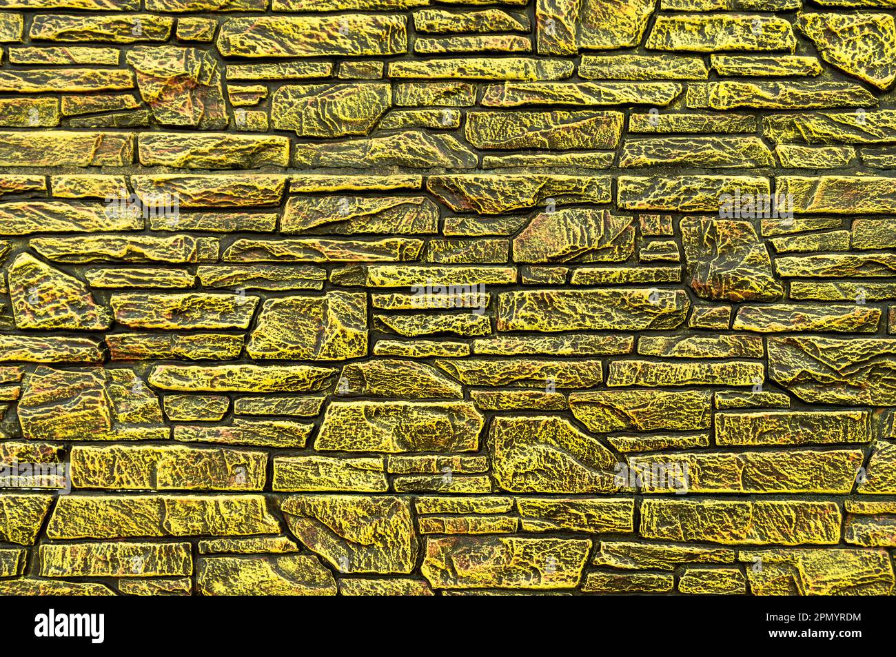 Pareti rivestite con moderno motivo in pietra artificiale gialla e sfondo Foto Stock