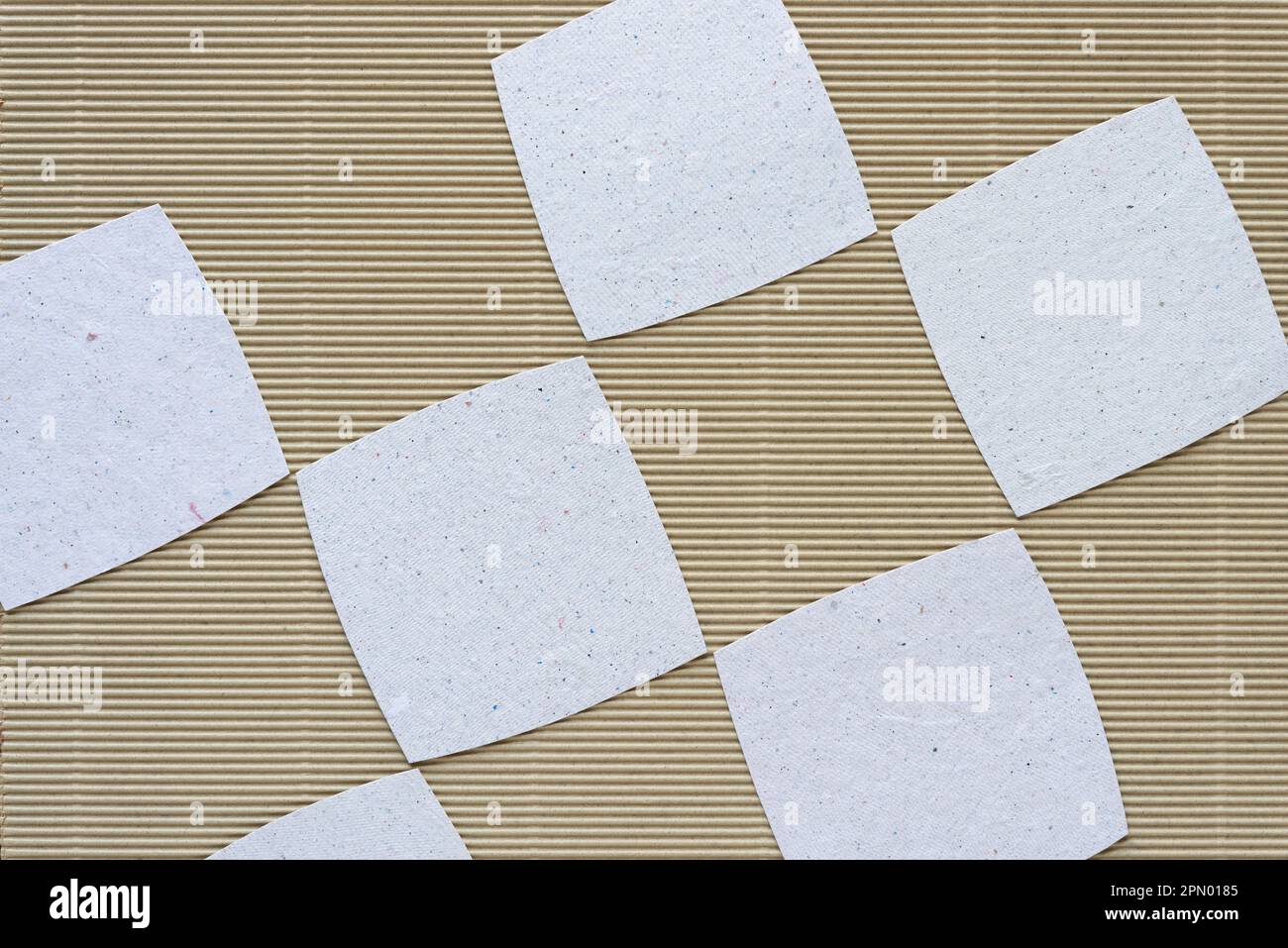 piastrelle di carta ruvida arrotondate su carta di cartone ondulato beige Foto Stock