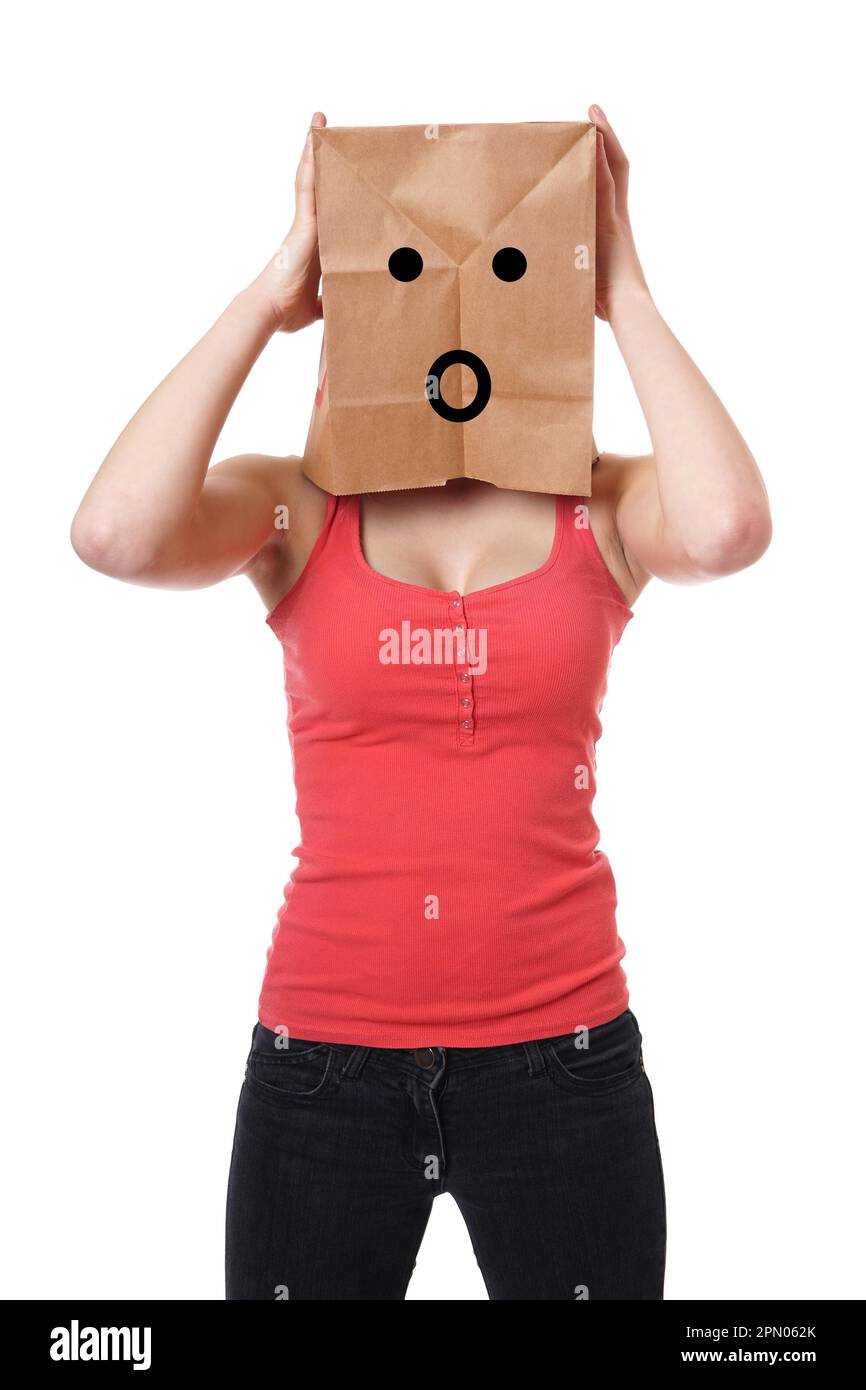 Giovane donna indossa sacchetto di carta con scioccato Smiley face sopra la testa Foto Stock