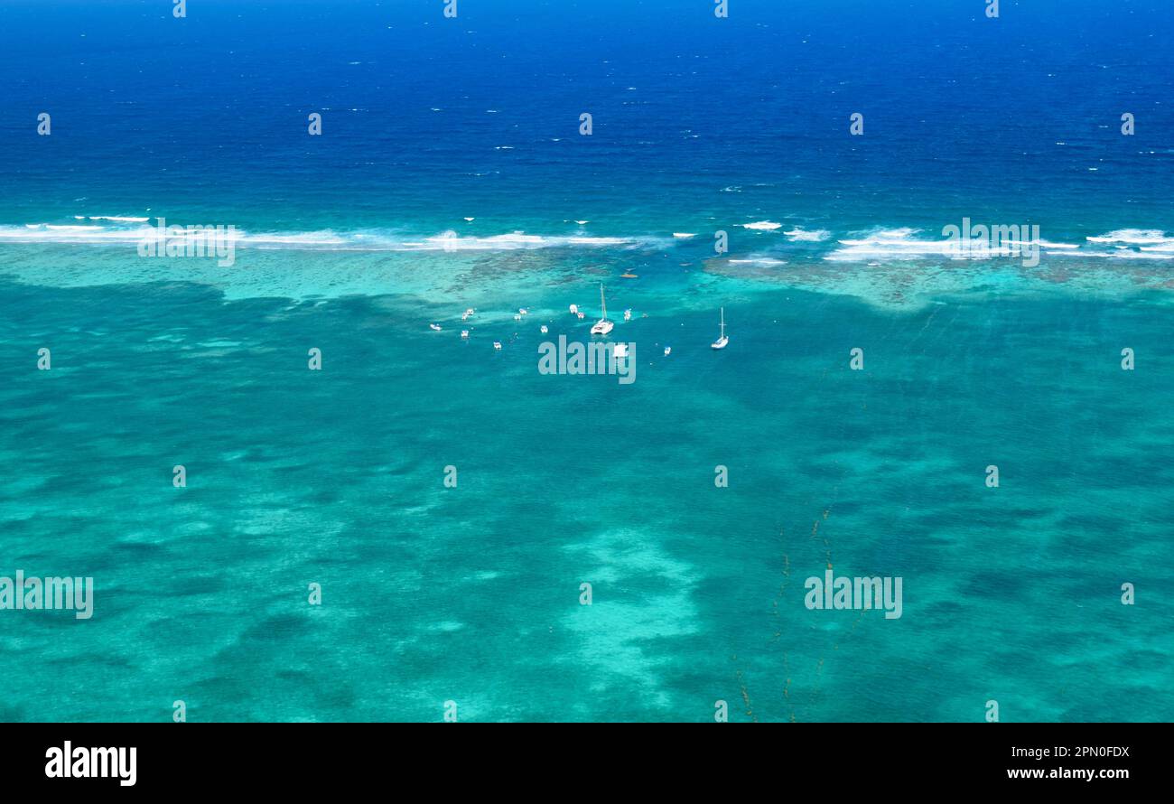 Una vista aerea della barriera Corallina del Belize con barche da visita vicino alla barriera corallina per i turisti che desiderano fare snorkeling. Foto Stock