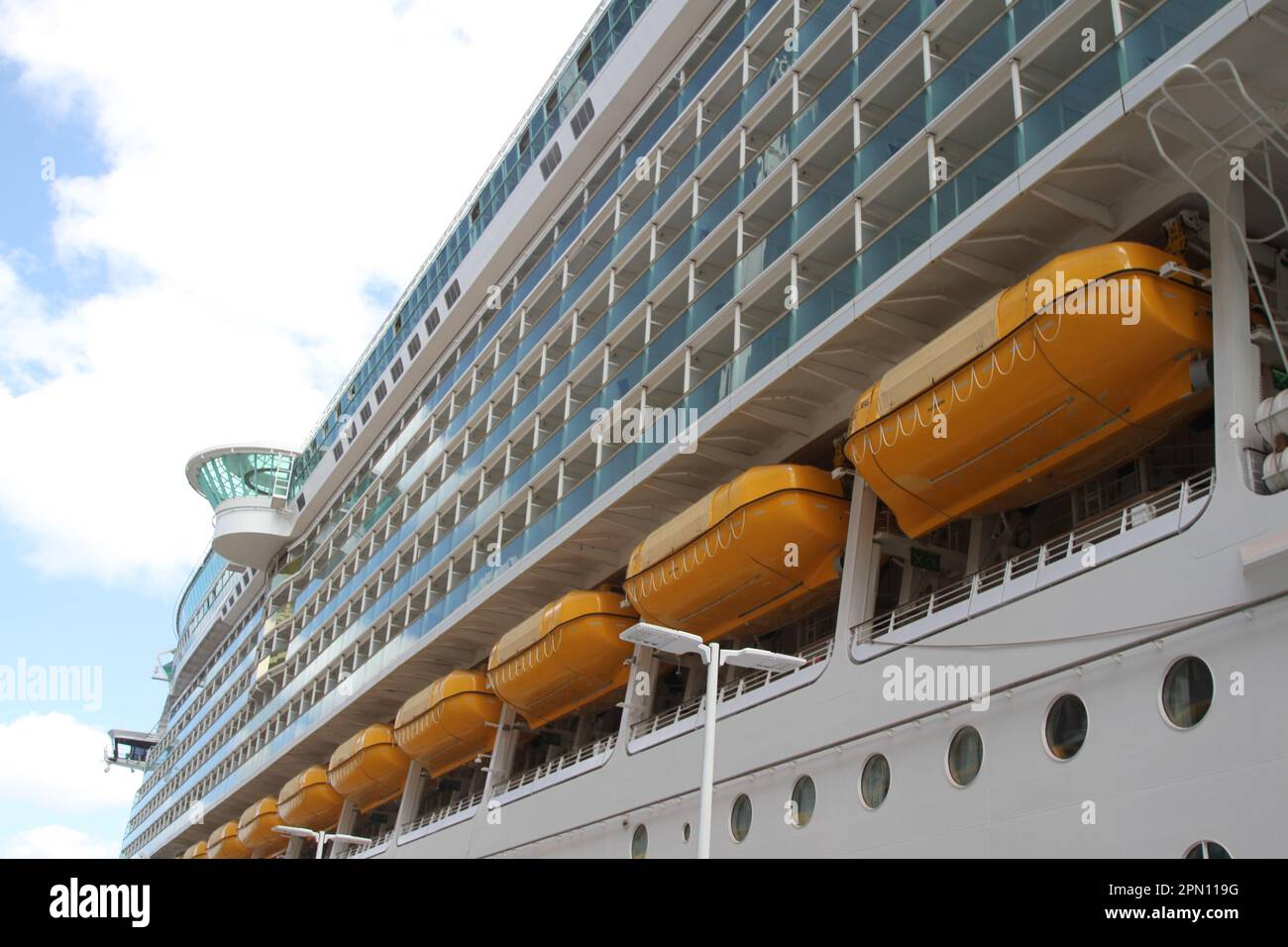 Nave da crociera passeggeri al porto con scialuppe di salvataggio gialle collegate Foto Stock