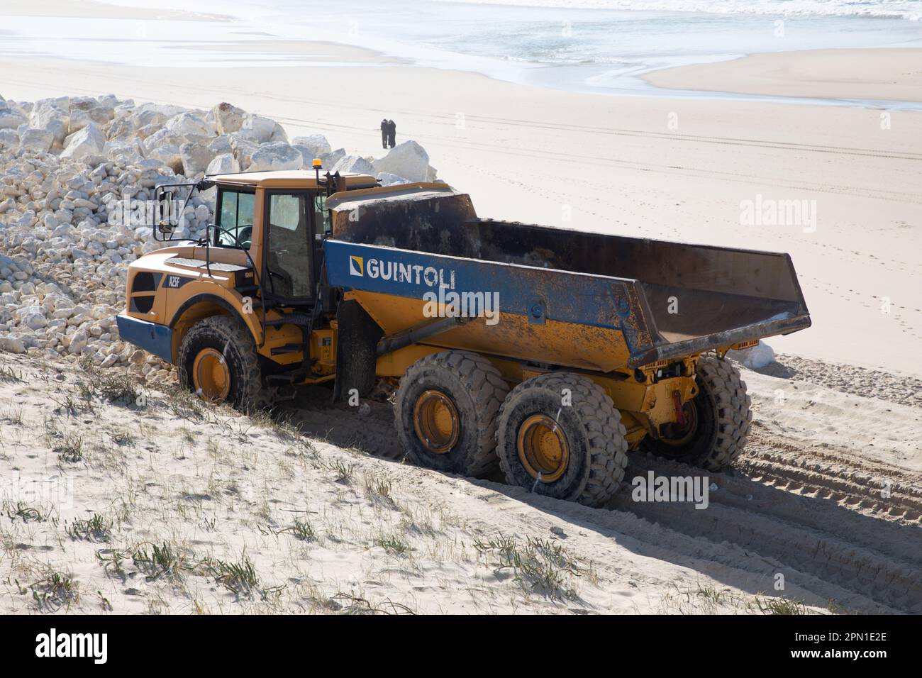 Bordeaux , Aquitaine France - 04 10 2023 : NGE Guintoli Big dump camion giallo correre su sabbia costa mare preparazione di una spiaggia per la stagione estiva Foto Stock