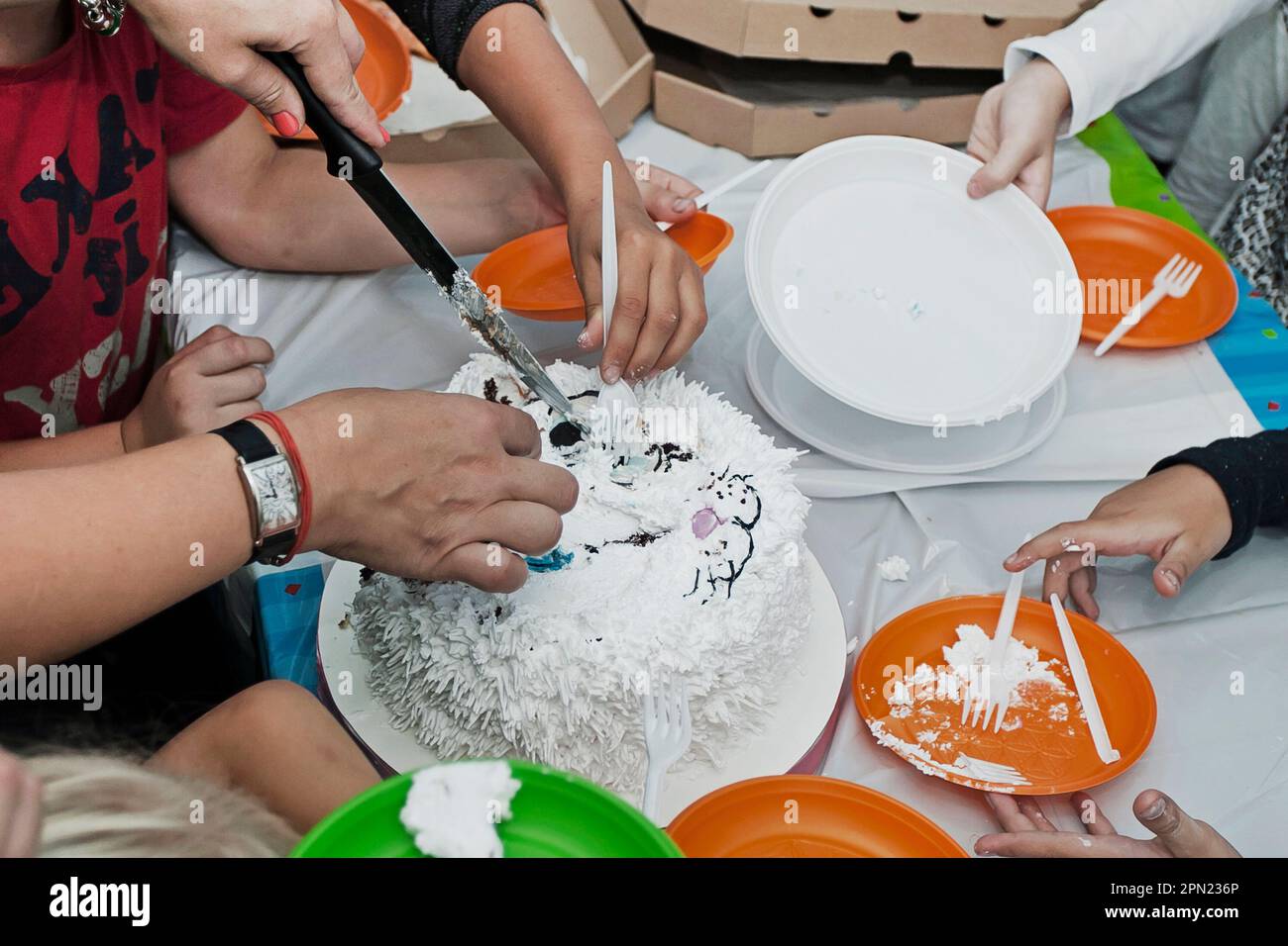 tagliare una bella torta sotto forma di gatto e al compleanno di un bambino. festa per bambini Foto Stock