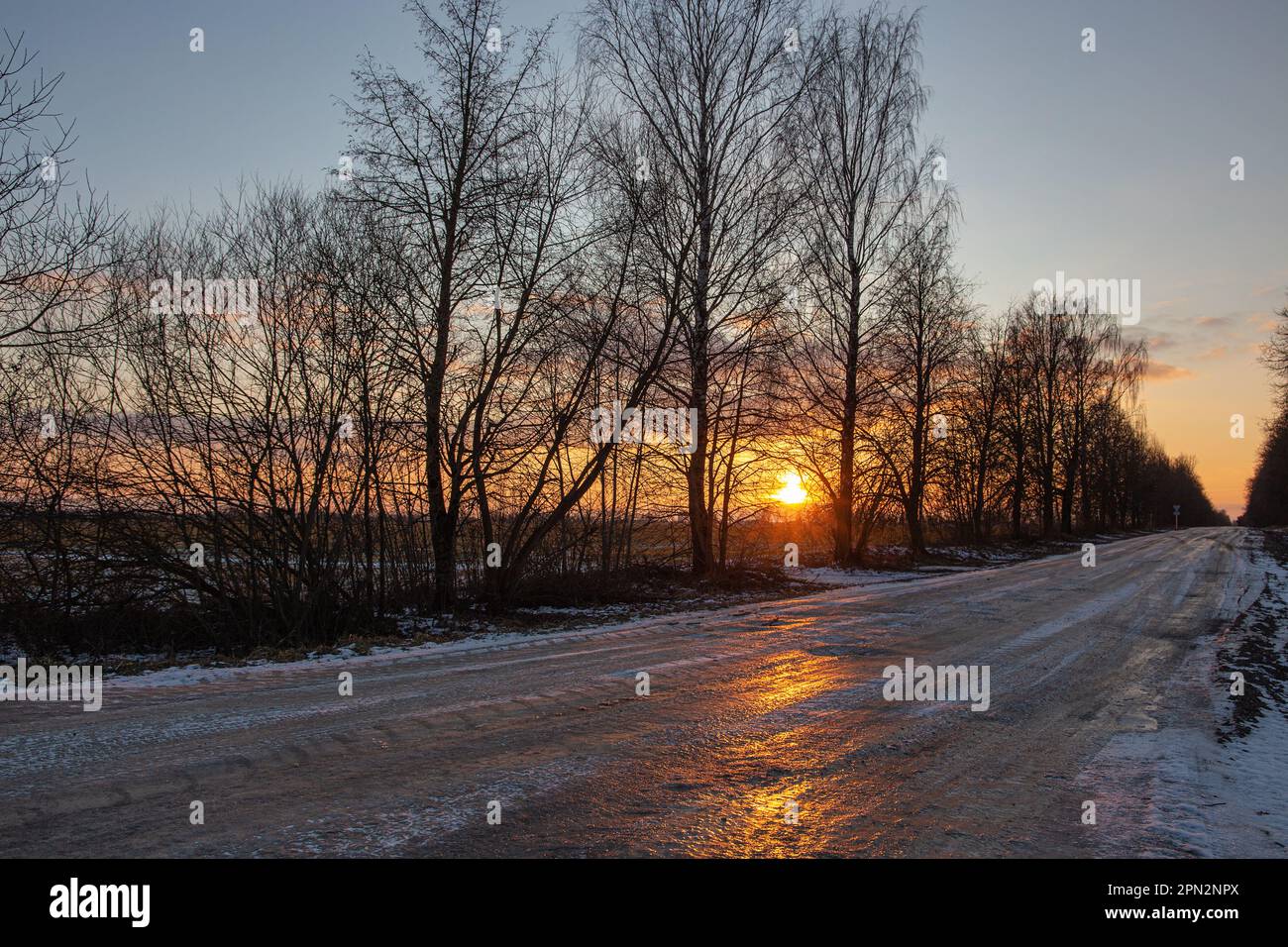 La strada invernale è illuminata dal tramonto. Il carattere congelato della Lituania Foto Stock