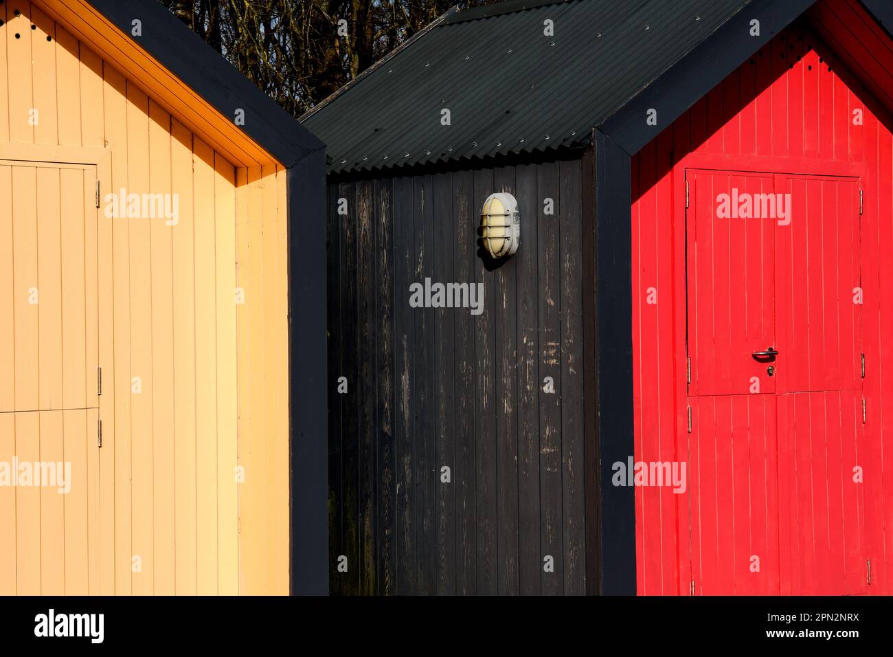 Capanne sulla spiaggia dipinte con colori luminosi situate in una zona costiera Foto Stock