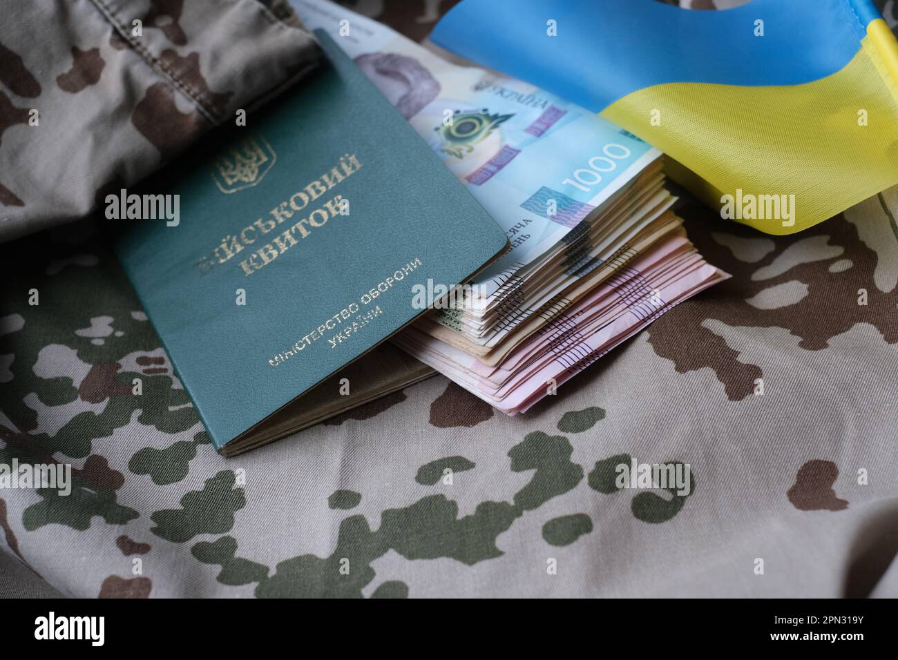 Carta d'identità militare Ucraina e hryvnia su uniforme militare. Pagamenti ai soldati dell'esercito ucraino, stipendi ai militari. Guerra in Ucraina Foto Stock