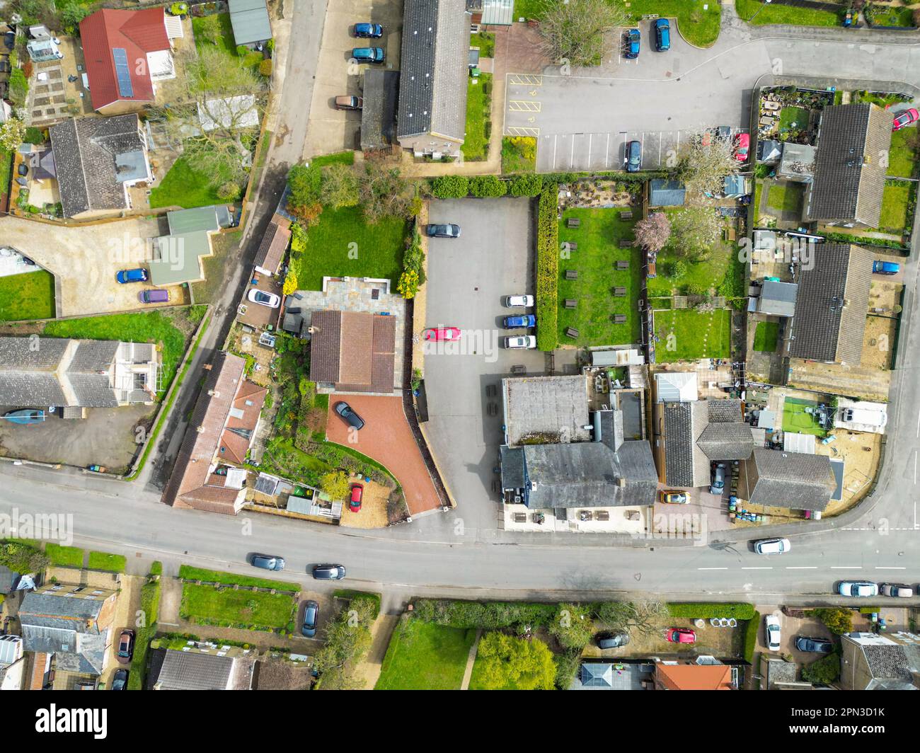 Veduta aerea dall'alto verso il basso del centro di un tipico villaggio inglese. Un pub e un grande parcheggio per carpe possono essere visti al centro dell'immagine. Foto Stock