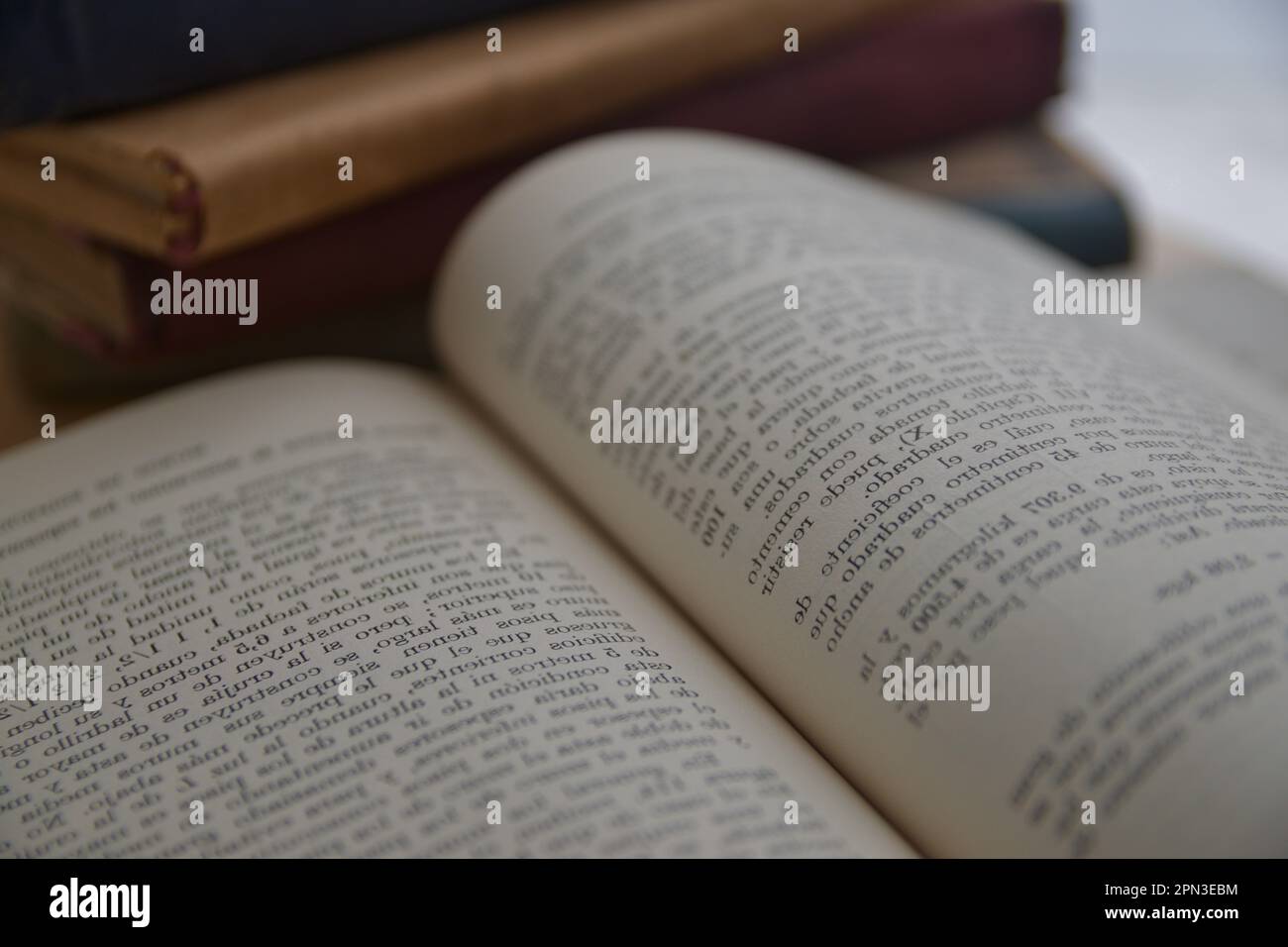 Immagine di una pagina sfocata e capovolta di un vecchio libro, accanto ad esso altri vecchi libri Foto Stock Immagine di una pagina sfocata e capovolta di un vecchio libro, accanto ad esso altri vecchi libri Foto Stock
