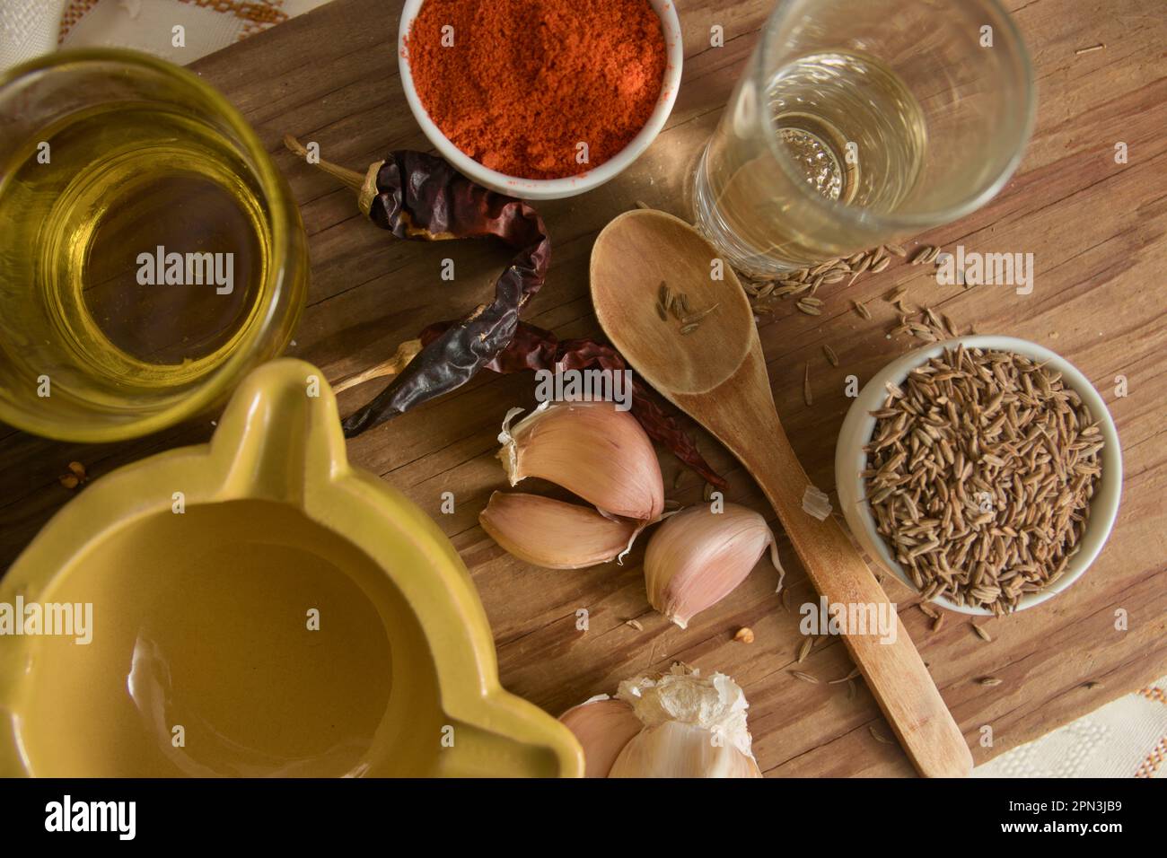 Vista dall'alto di una tavola di legno con alcuni degli ingredienti necessari per preparare la salsa rossa mojopicón, una salsa delle Canarie Foto Stock Vista dall'alto di una tavola di legno con alcuni degli ingredienti necessari per preparare la salsa rossa mojopicón, una salsa delle Canarie Foto Stock