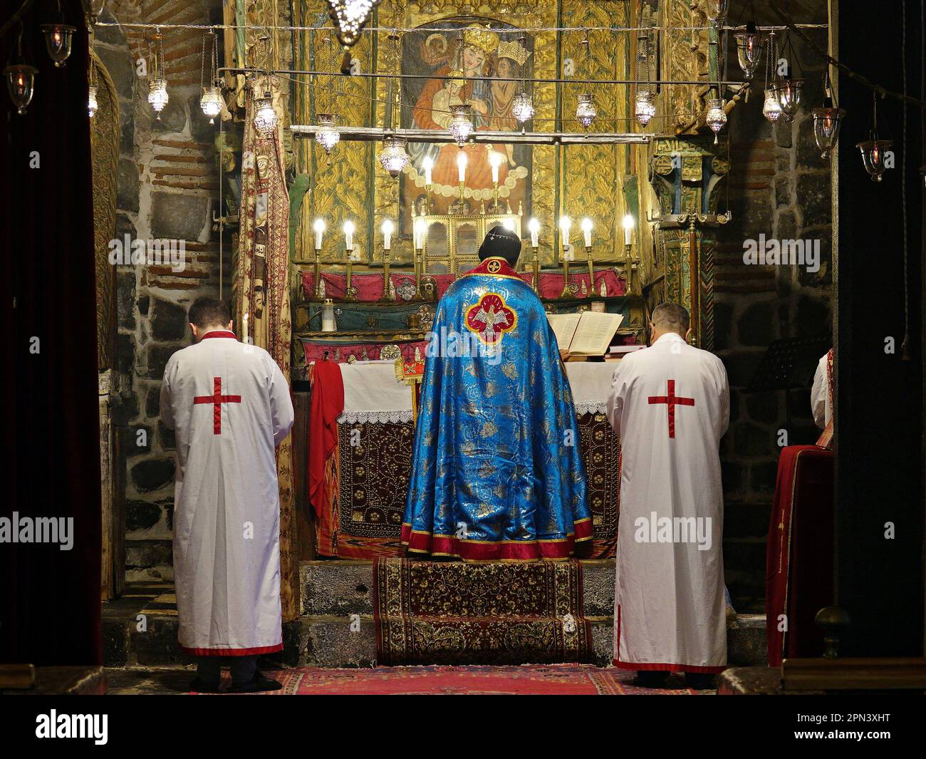 Il sacerdote Behnam Konuttan dirige la messa nella Chiesa della Vergine Maria a Diyarbakir con i suoi due assistenti. Gli ultimi assiri di Diyarbakir, composti da due famiglie e da un totale di 12 persone, hanno celebrato la festa pasquale con una messa nella Chiesa della Vergine Maria. Il sacerdote Behnam Konuttan, commissionato al Monastero di Mardin Deyrul Zaferan perché nella città non c'era alcun chierico che potesse amministrare il rito, lo dirigeva. Alla messa hanno partecipato anche un piccolo numero di assiri e i loro amici armeni. Dopo la messa, i panini e le uova rosse sono stati serviti all'ospite Foto Stock