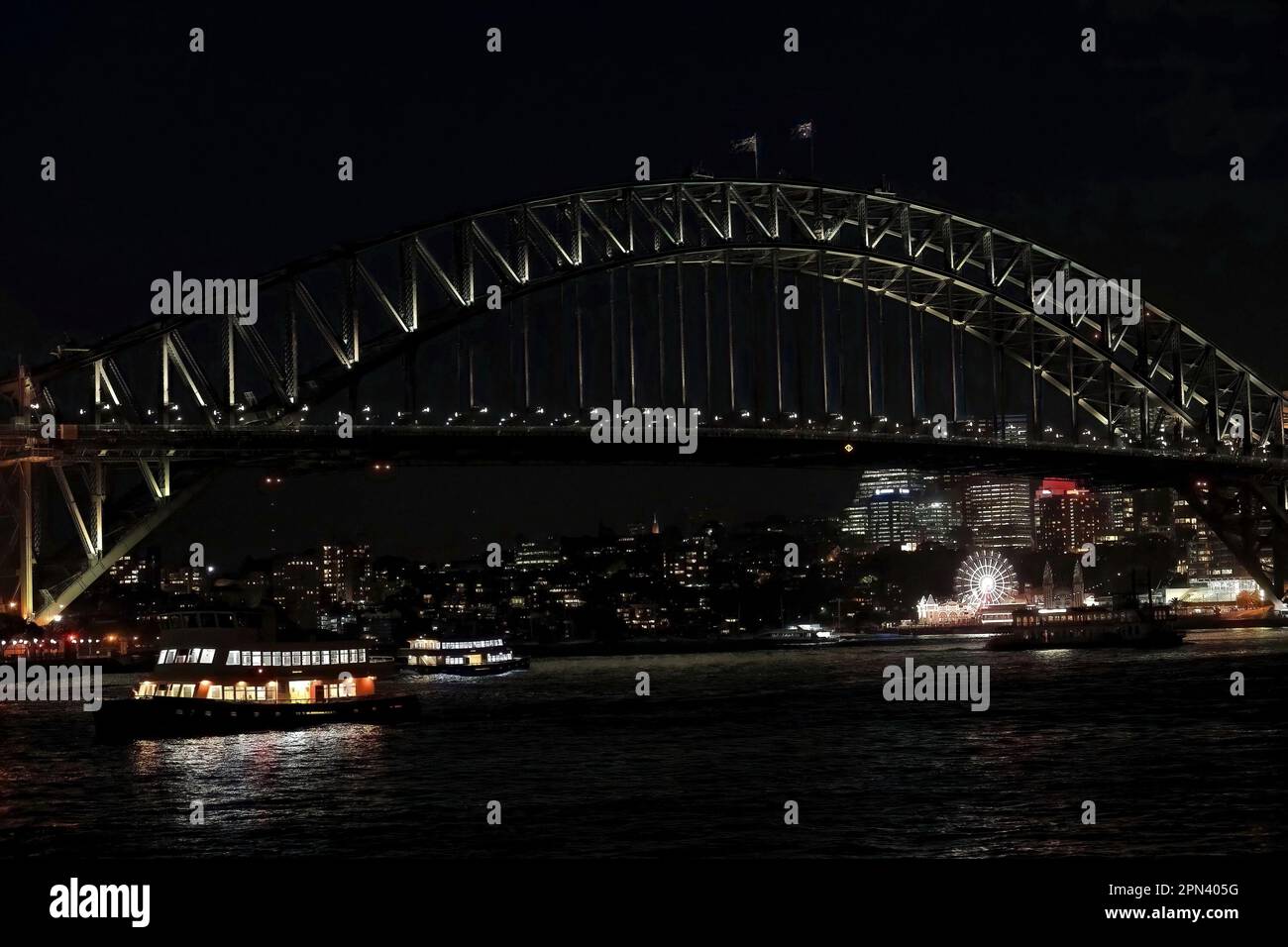 589 Sydney Harbour Bridge, arco e piloni sotto il proiettore, visti di notte dall'Opera House. NSW-Australia. Foto Stock