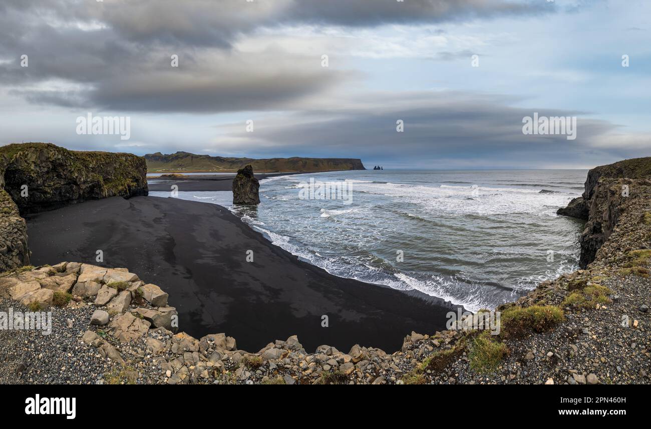 Pittoresca vista autunnale serale della spiaggia di sabbia vulcanica nera dell'oceano di Reynisfjara e delle formazioni rocciose da Capo di Dyrholaey, Vik, Islanda del Sud. Monte Rey Foto Stock