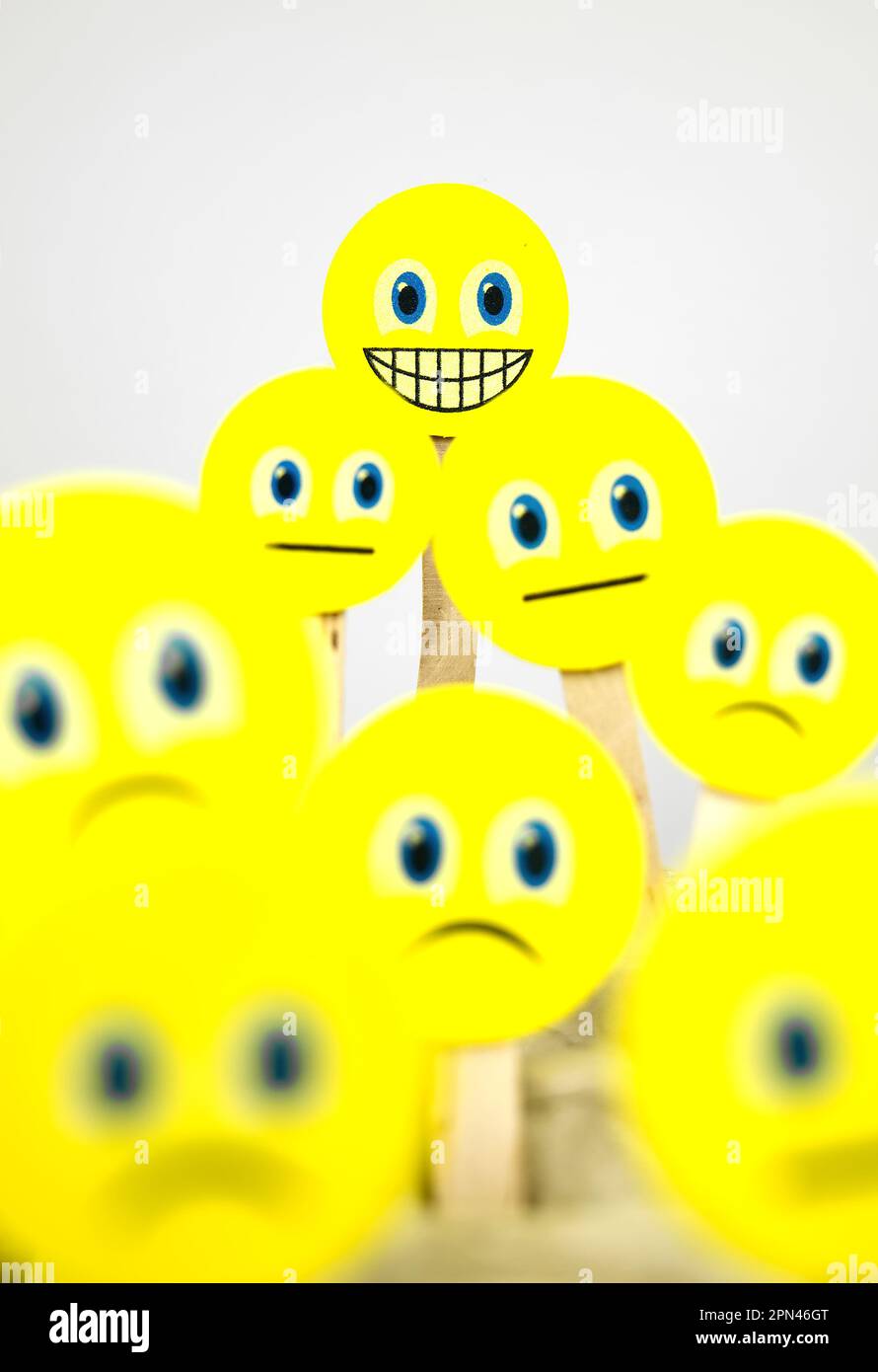 Primo piano di emoji facciali sorridenti tra emoji tristi Foto Stock