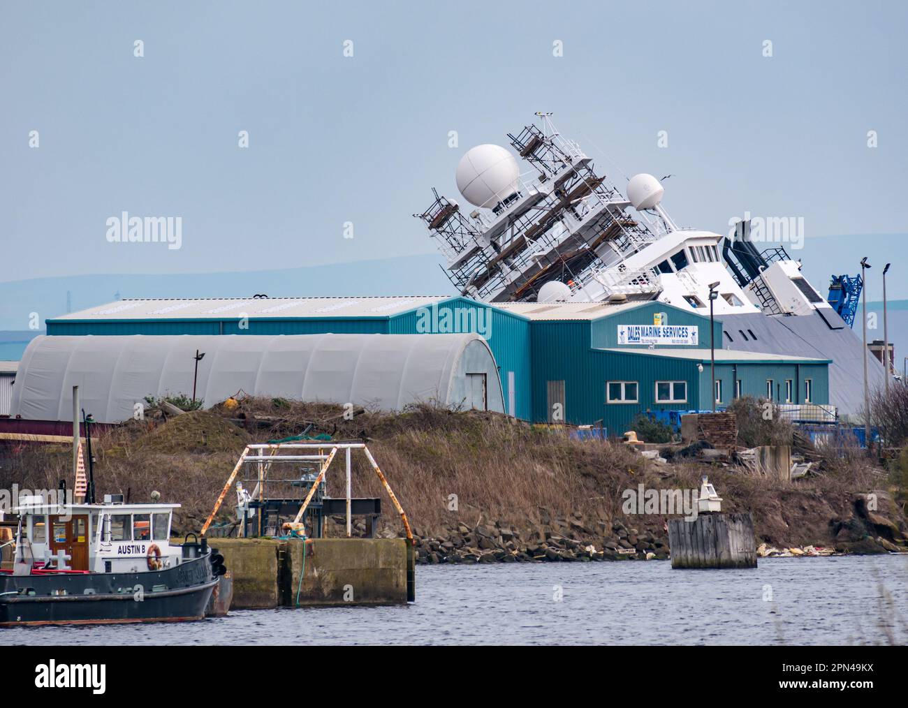 Nave Petrel giacente sul suo lato in bacino di carenaggio dopo il ribaltamento in un incidente, Leith Harbour, Edimburgo, Scozia, Regno Unito Foto Stock