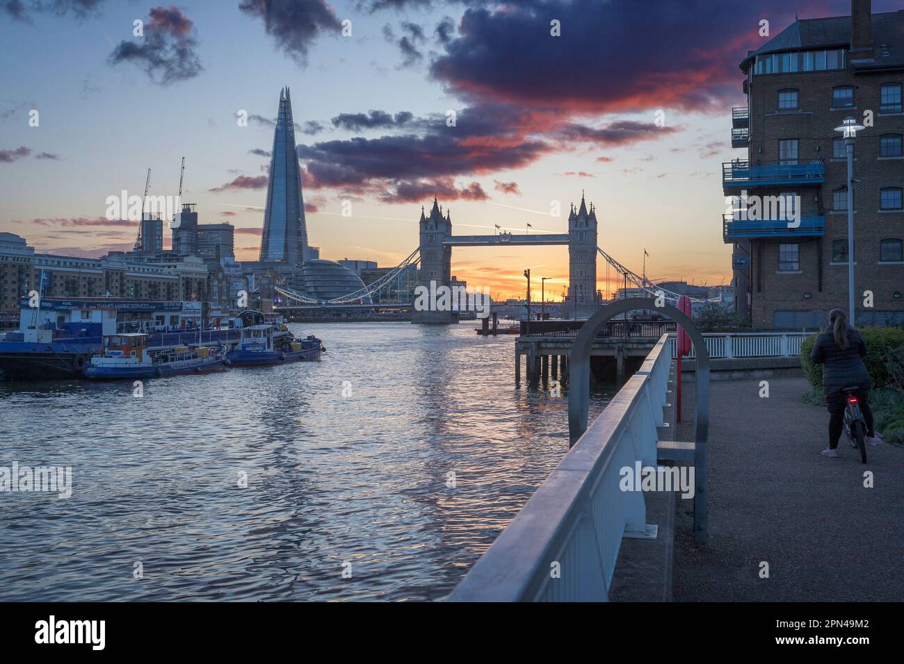 Un ciclista si meraviglia al magico tramonto dietro il Tower Bridge, Londra Foto Stock