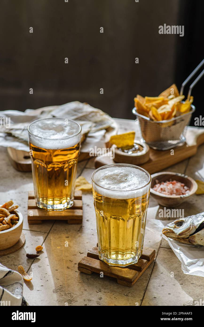 birra con pesce secco e nachos e noci. Foto di alta qualità Foto Stock