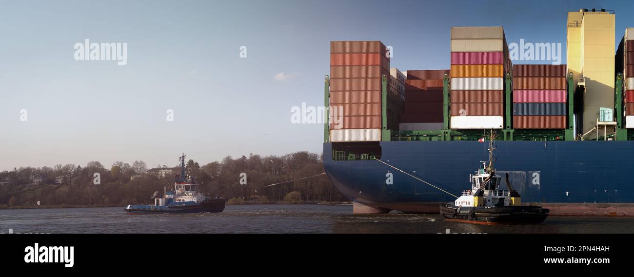 Una grande nave portacontainer arriva nel porto di Amburgo con il sole Foto Stock