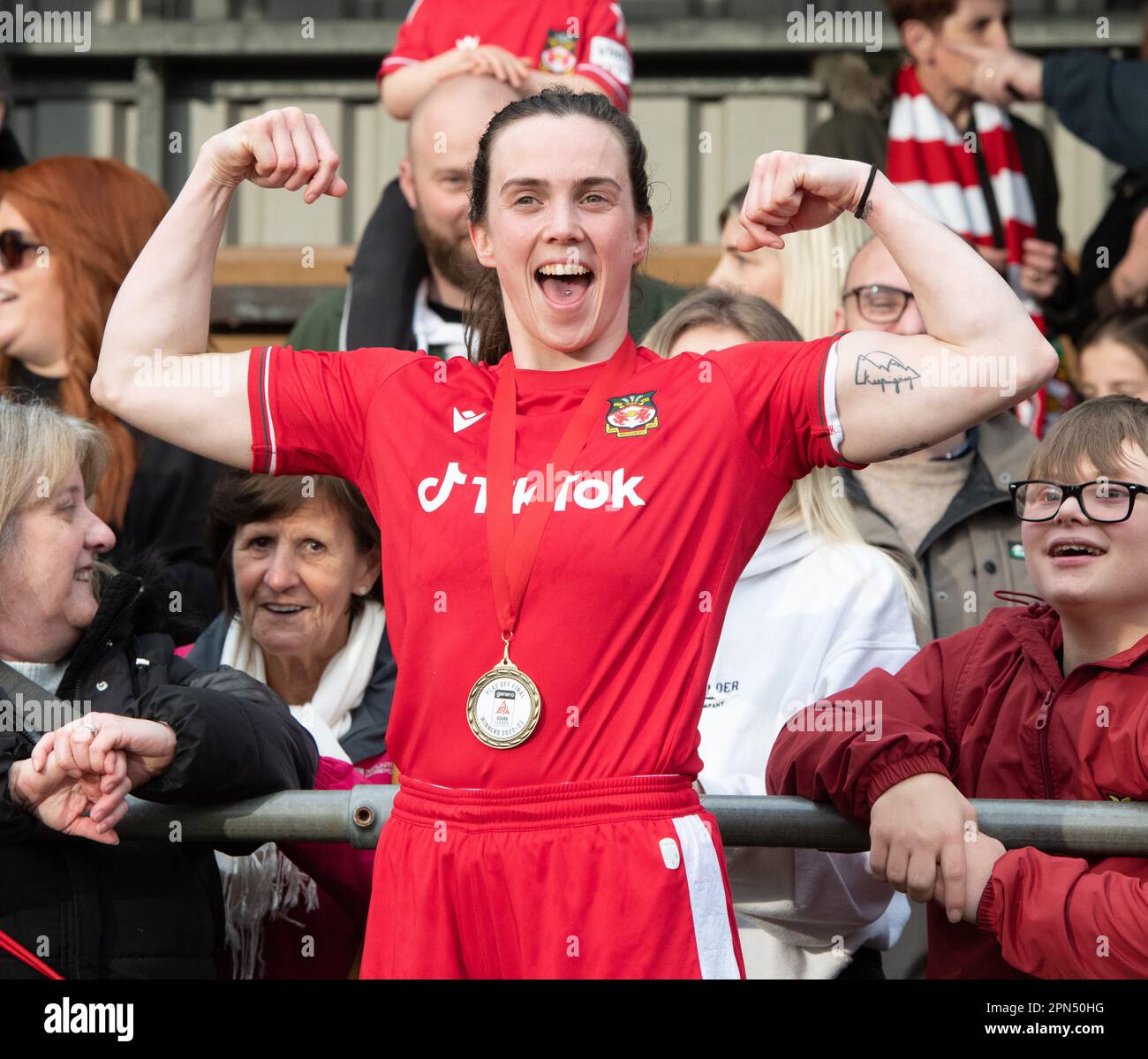 Newtown, Powys Wales, 16th aprile 2023. L'attaccante di Wrexham Rosie Hughes celebra la vittoria del play-off con i tifosi a tempo pieno, durante le donne del club di calcio di Wrexham Association Football Club di Briton Ferry Llansawel Athletic, nel play-off del generale Adran (Credit Image: ©Cody Froggatt Alamy live news) Foto Stock