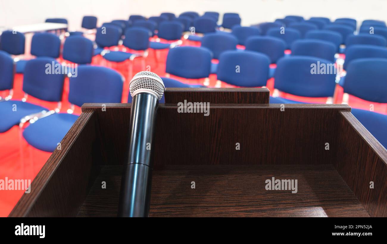 Tribune con microfono in una sala conferenze. interno della moderna sala conferenze. Sedie nella sala conferenze Foto Stock