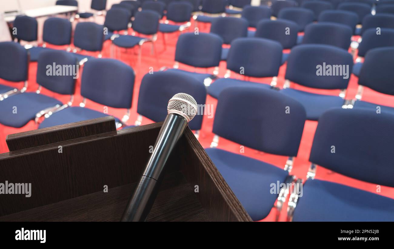 Tribune con microfono in una sala conferenze. interno della moderna sala conferenze. Sedie nella sala conferenze Foto Stock