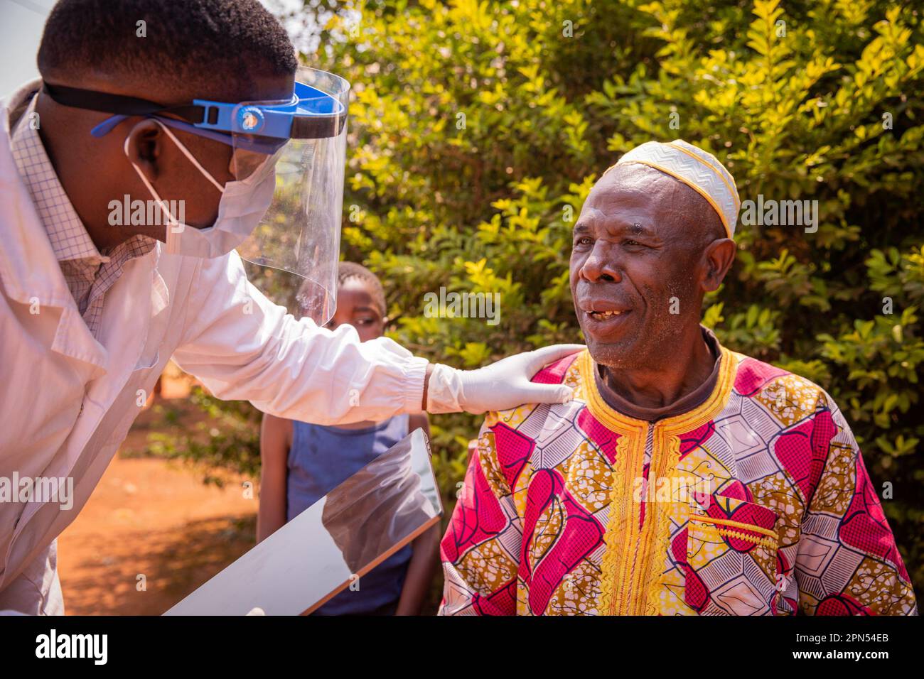 Un medico africano parla con un paziente anziano durante una visita medica. Foto Stock