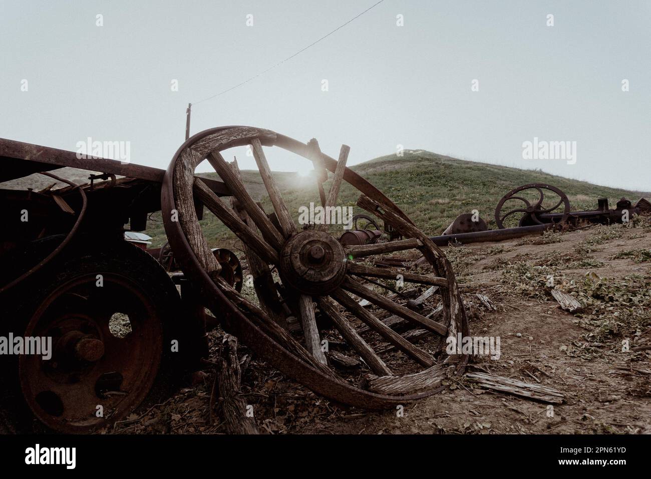 Una ruota del carro rotta tra le vecchie attrezzature arrugginite su una collina vicino a Mentryville, la città petrolifera dove Chevron ha cominciato nelle colline a nord di Los Angeles. Foto Stock