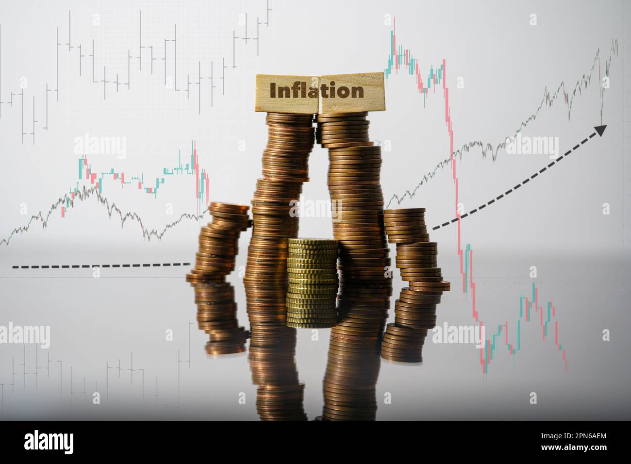 Concetto di inflazione. Parola di inflazione scritta su mattoni di legno su monete stack Foto Stock