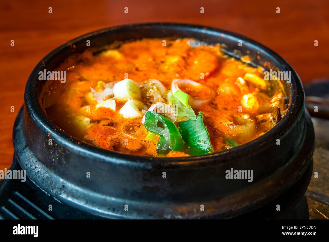 Il Sundubu-jigae è un jigae di cucina coreana. Il piatto è fatto con tofu morbido appena arricciato che non è stato teso e pressato, verdure, som Foto Stock