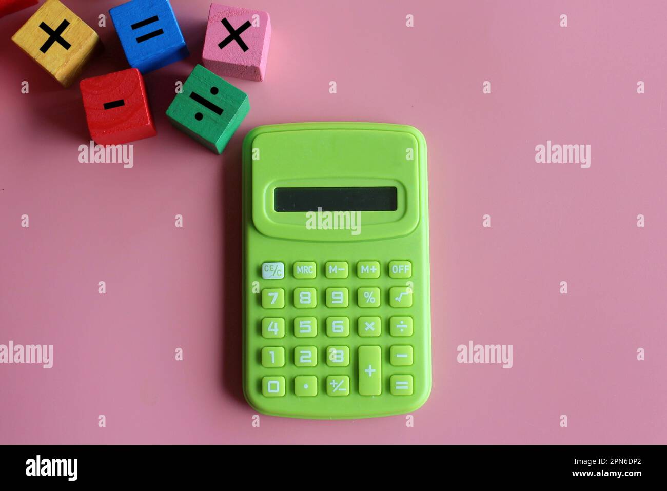 Calcolatrice e cubetti di legno con simbolo matematico. Educazione e concetto matematico Foto Stock
