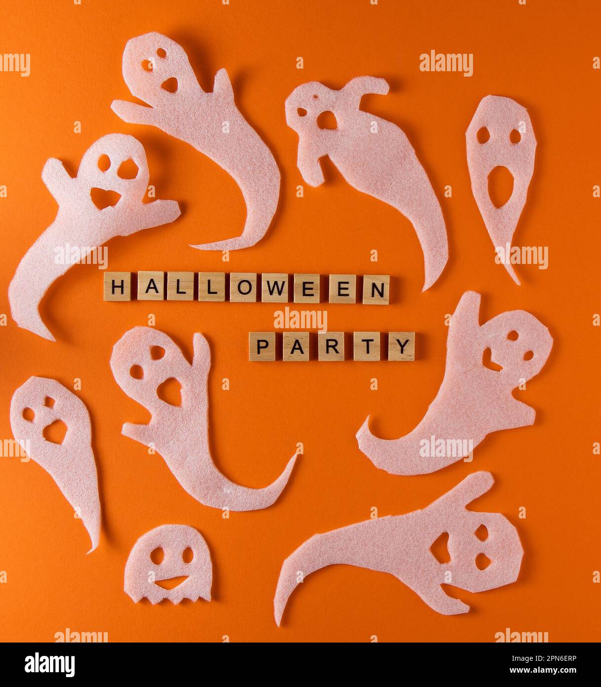 Fantasmi bianchi per la festa di Halloween. Immagine fantasma della carta di avvolgimento su sfondo arancione vista dall'alto. Fumetto Creepy Whisper. Fai-da-te fatto a mano. Impostare i caratteri boo. Parola frase di legno della lettera. Foto Stock