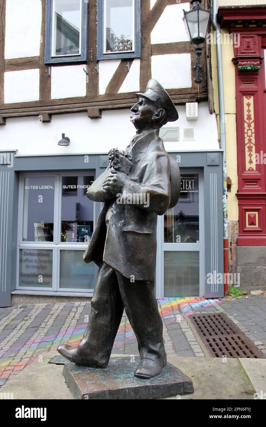Statua di bronzo 'il portatore', rappresenta Christian Werner, l'ultimo portabagagli della città, di Paul Wedepohl, installato nel 1988, Marburg, Assia, Germania Foto Stock