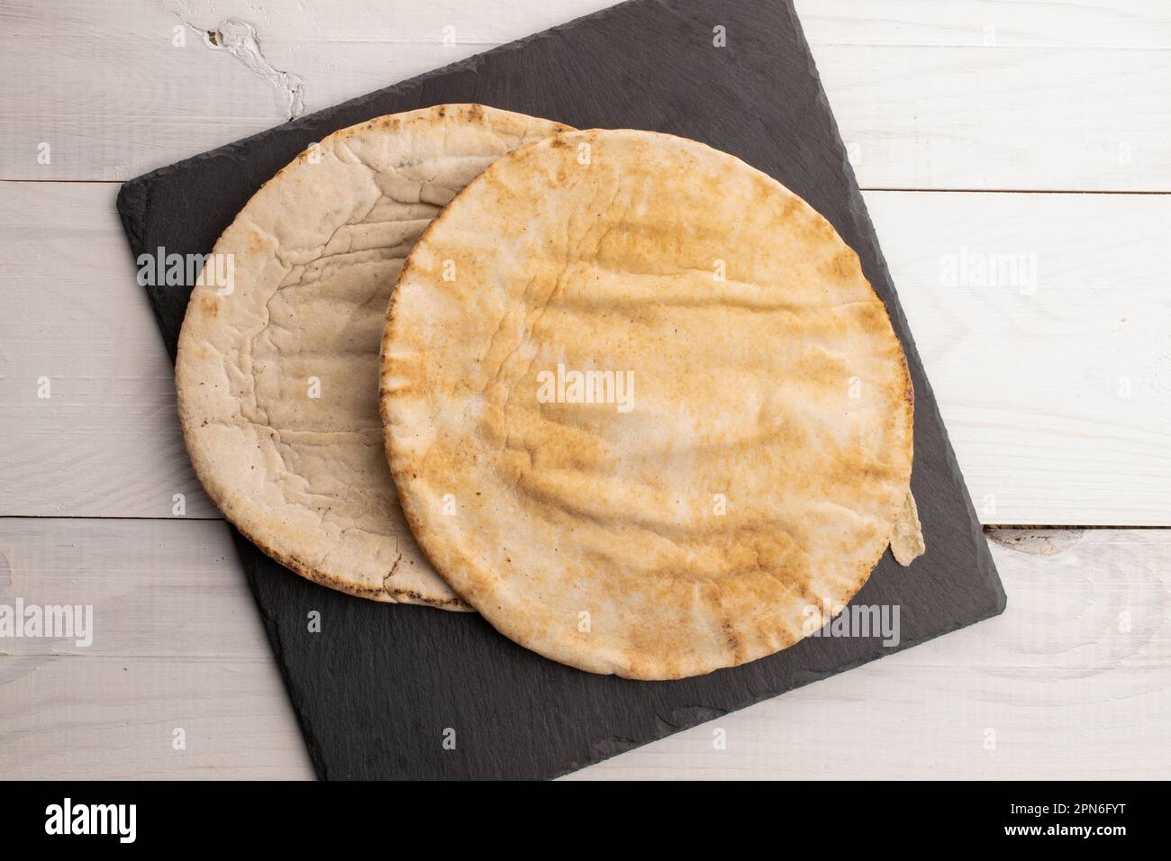 Due pita al forno, primo piano, su un tavolo di legno, vista dall'alto. Foto Stock