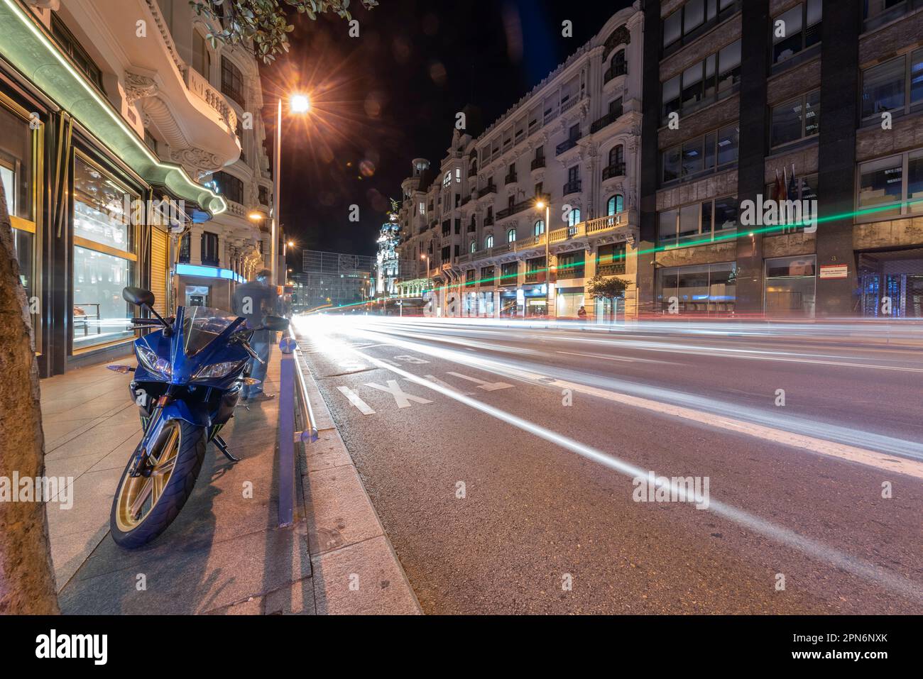 Edifici storici in Gran Via a Madrid di notte con sentieri leggeri Foto Stock