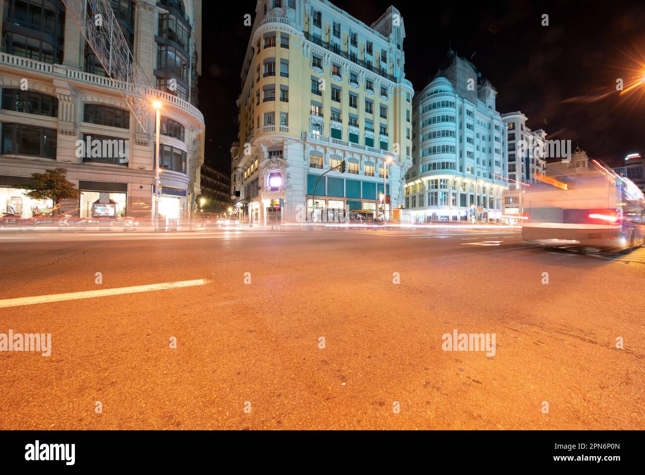 Edifici storici in Gran Via a Madrid di notte con sentieri leggeri Foto Stock