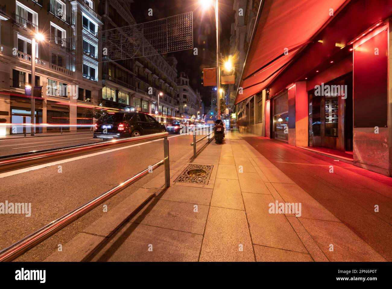 Edifici storici in Gran Via a Madrid di notte con sentieri leggeri Foto Stock