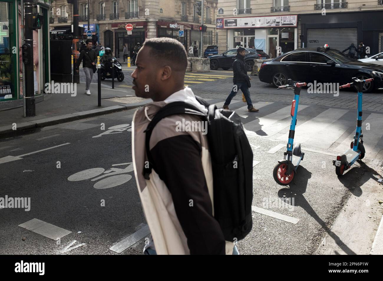 Persone a piedi noleggio e-scooter parcheggiati sulla strada in un'area di parcheggio designata dipinta sul terreno, a Parigi, Francia. Foto Stock