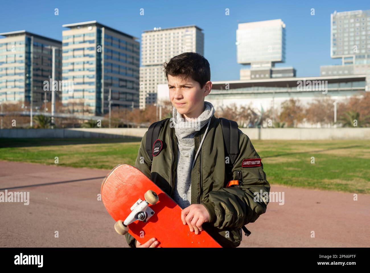 Foto di un giovane uomo che tiene uno skateboard all'esterno. Foto Stock