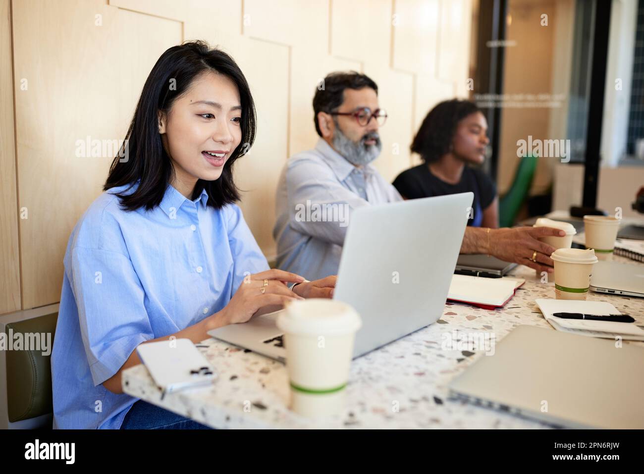 donna d'affari che effettua videochiamate sul computer portatile mentre è seduta in caffetteria Foto Stock