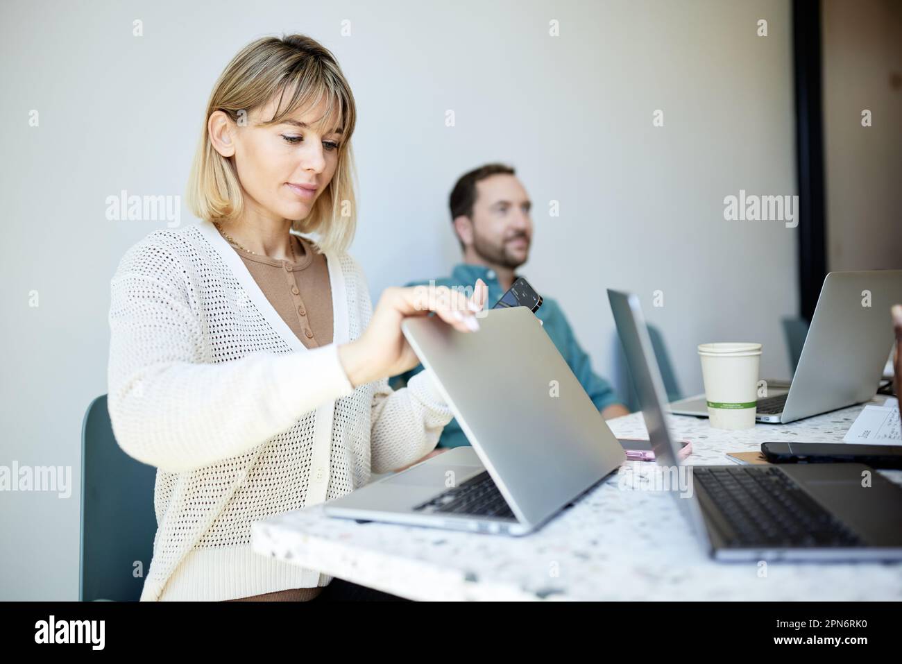 donna d'affari che apre un computer portatile sul tavolo seduto nel bar Foto Stock