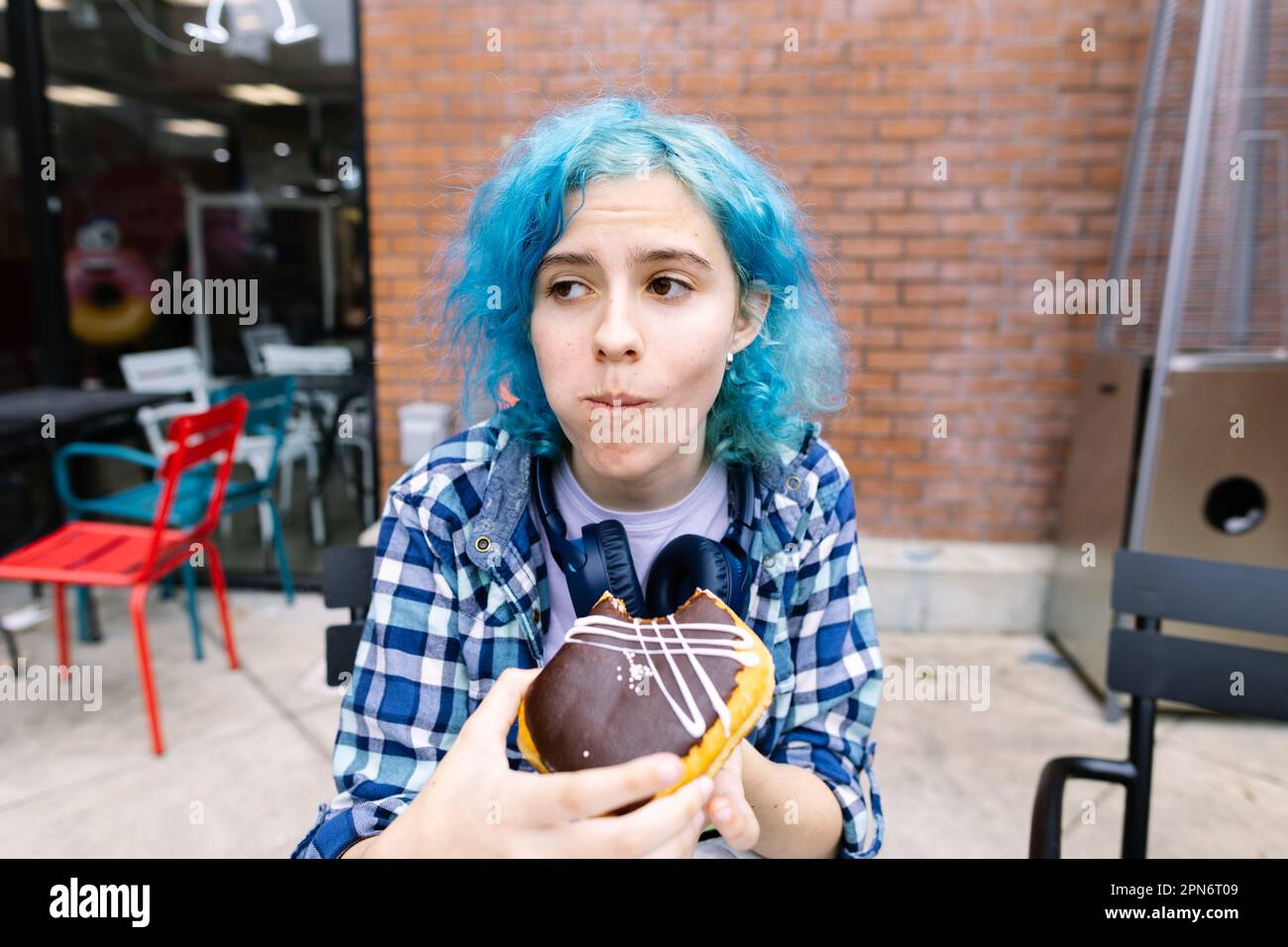 Ragazza teen con capelli blu appena ha preso Una vite di Un Doughnut Foto Stock