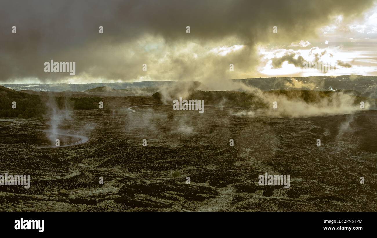Le nuvole basse si schiariscono dopo una tempesta, rivelando la distesa di lava lungo le pendici del vulcano Etna. Parco Nazionale dell'Etna, Sicilia, Italia, Europa Foto Stock