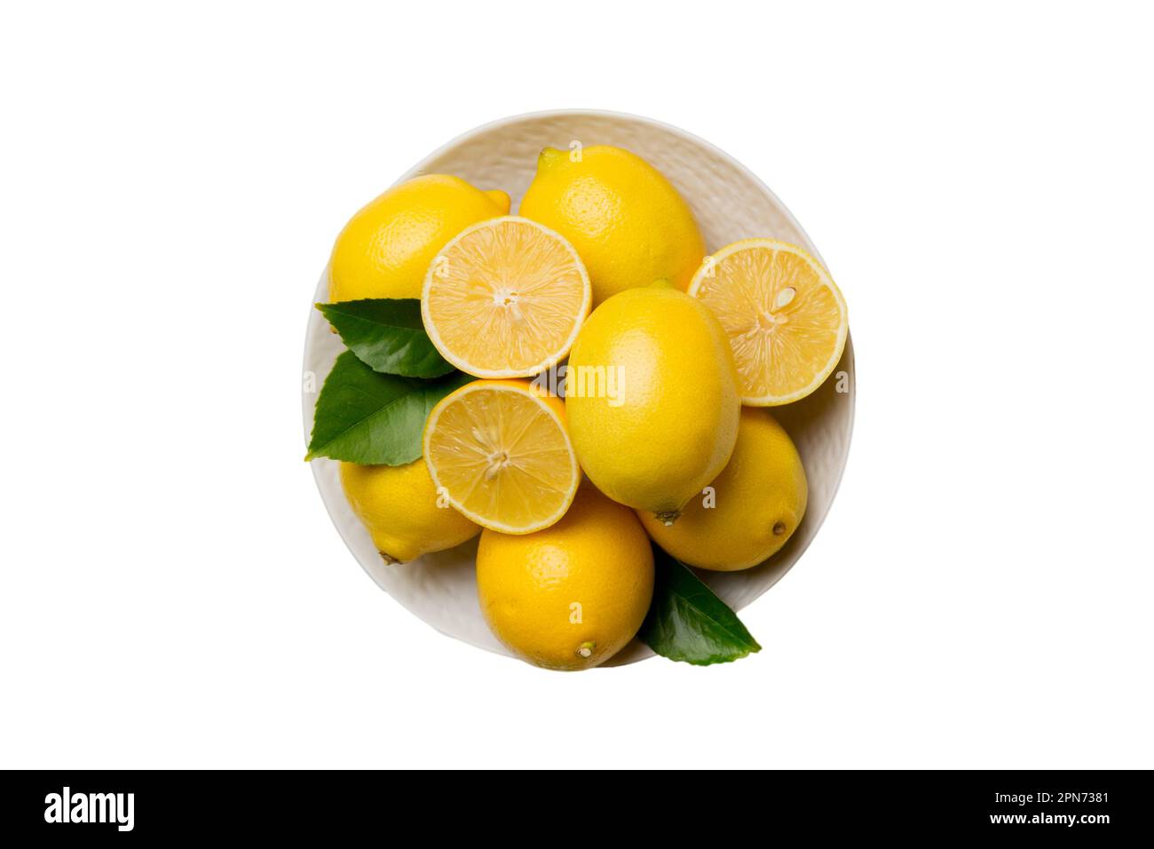 Limone fresco tagliato e limoni interi su piatto rotondo isolato su fondo bianco. Alimenti e bevande ingredienti preparazione. sana mangiare tema vista dall'alto Foto Stock