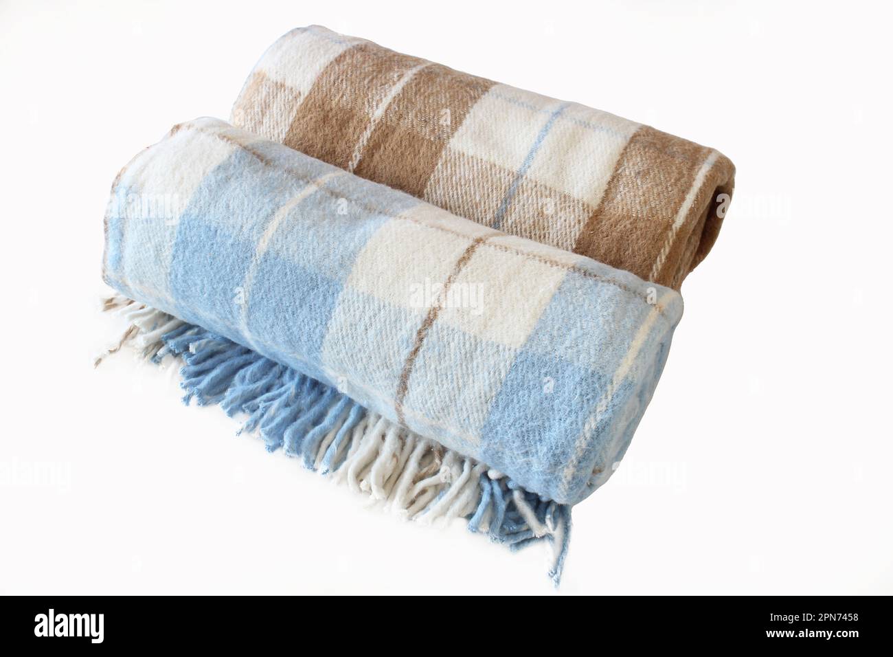 Coperta in lana a quadri isolata su fondo bianco. Coperta arrotolata beige-marrone e bianco-blu. Primo piano. Foto Stock