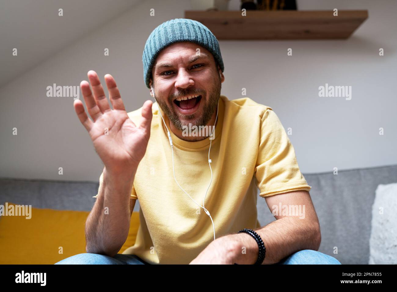 L'uomo sorride e agita la mano durante il meeting online saluto partecipanti di videochiamata. Foto Stock